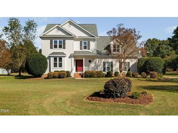 Traditional two-story home with landscaped front yard and charming red front door at 3648 Praed Pl, Fuquay Varina, NC 27526