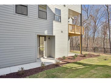 Side exterior of home with a small balcony, landscaping and secondary entrance at 4501 Mint Leaf Ln, Raleigh, NC 27612