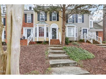 Charming townhomes with brick and siding exteriors and well-maintained front lawns and landscaped front yard at 4523 Hamptonshire Dr, Raleigh, NC 27613