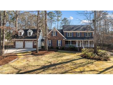 Traditional brick home with blue shutters, white trim, a lush green lawn, and an attached two car garage at 5317 Chimney Swift Dr, Wake Forest, NC 27587