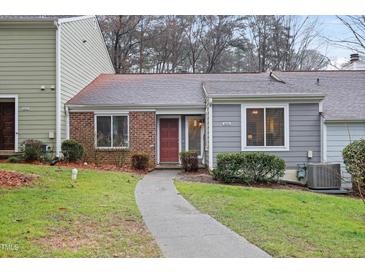 Charming townhouse featuring a well-manicured front yard and a welcoming red front door at 5840 Branchwood Rd, Raleigh, NC 27609