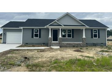 Charming single-story home features a gray exterior, stone accents, and a cozy front porch at 82 Asher Pointe Way, Benson, NC 27504