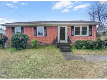 Charming brick home with well-maintained front yard and classic architectural details, offering a welcoming curb appeal at 1004 Carlisle St, Raleigh, NC 27610