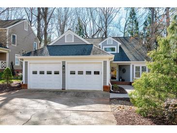 Charming gray home featuring a two-car garage, dormers, and a professionally landscaped yard at 115 Ripplewater Ln, Cary, NC 27518