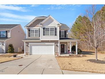 Charming two-story home featuring a well-manicured lawn, inviting front porch, and attached two-car garage at 127 Lakemont Dr, Clayton, NC 27520