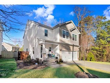 Charming two-story home featuring stone accents, a two-car garage, and a well-manicured lawn at 13 Piccadilly Ct, Durham, NC 27713