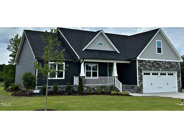Charming single Gathering home with a white garage door, lovely front porch, and well-manicured front lawn at 143 Prency Ln, Middlesex, NC 27557