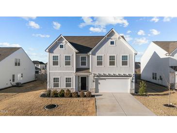 Charming two-story home with neutral siding, well-kept lawn, and attached two car garage at 158 Arlie Ln, Lillington, NC 27546