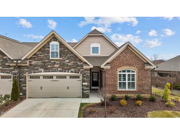 Charming home featuring stone and brick accents, a two-car garage, and a beautifully landscaped front yard at 170 Dunvegan Ln, Burlington, NC 27215