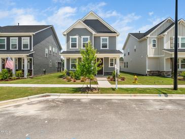 Charming two-story home with gray siding, a landscaped yard, and a welcoming front porch at 1981 Rosedale Ridge Ave, Wake Forest, NC 27587