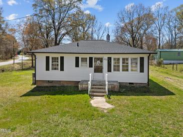 Charming single-story home with a white exterior, dark shutters, and a well-maintained lawn at 202 Harper Rd, Hillsborough, NC 27278