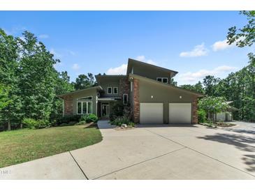 Stunning contemporary home featuring a two-car garage, stone accents, and professional landscaping at 295 Cedar Rock Trl, Fuquay Varina, NC 27526