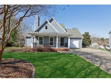 Charming single-Gathering home with well-maintained lawn, inviting front porch, and attached garage at 3213 Leebrook Rd, Raleigh, NC 27616