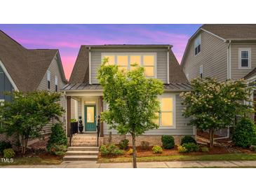 Charming two-story home with landscaped front yard, teal door, and inviting curb appeal at 5520 Advancing Ave, Raleigh, NC 27616