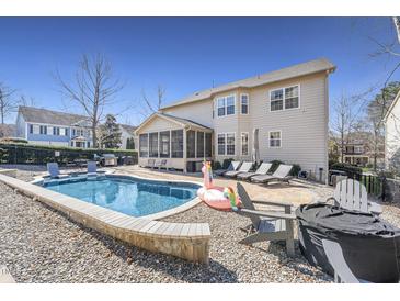 Relaxing backyard with a beautiful in-ground pool, lounge chairs, and screened in porch at 109 Skywater Ln, Holly Springs, NC 27540