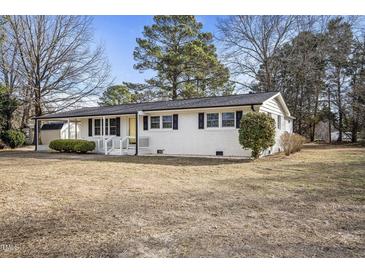 Charming white-brick ranch home with black shutters and a welcoming front porch, nestled in a wooded yard at 11254 Hwy Nc 50, Benson, NC 27504