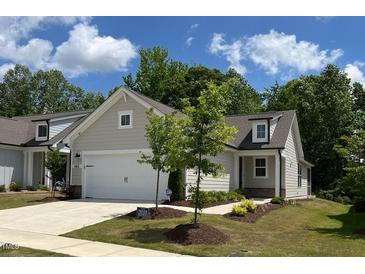 Charming home featuring a light-colored exterior, well-manicured lawn, and a two-car garage at 1413 Buxus Ct, Fuquay Varina, NC 27526