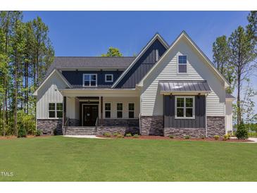 Charming two-story home featuring a manicured lawn and welcoming front porch at 15 Harvest View Way, Franklinton, NC 27525