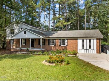 Charming brick home with well-maintained landscaping and a welcoming front porch at 208 Hardwood Ridge Ct, Clayton, NC 27520