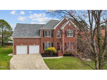 Charming two-story brick home with a well-manicured lawn, attached two-car garage, and mature landscaping at 3208 Marblewood Ct, Raleigh, NC 27604