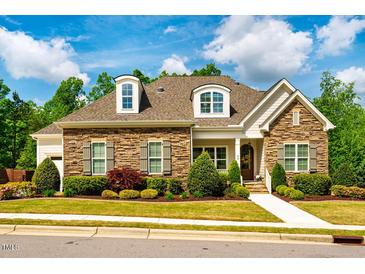 Charming, stone-accented home features dormer windows, manicured landscaping, and a welcoming entrance at 44 Ashwood Dr, Chapel Hill, NC 27516