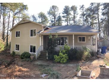 Charming two-story home featuring a cozy covered porch and mature trees at 4401 Sprague Rd, Raleigh, NC 27613