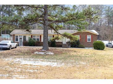 Charming single-story home featuring a brick facade and a well-maintained front yard with mature trees at 722 Forge Rd, Durham, NC 27713