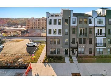 Modern townhome with brick and siding facade, showcasing contemporary design and inviting curb appeal in a residential area at 1259 Shaw View Alley # 201, Raleigh, NC 27601