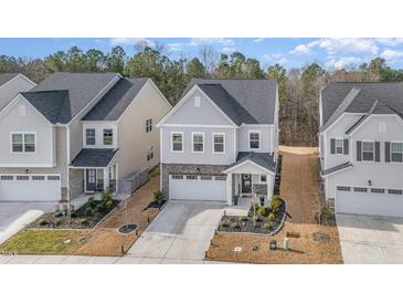 Charming two-story home featuring a stone-accented front, well-manicured landscaping, and a two-car garage at 2212 Jollay St, Durham, NC 27703