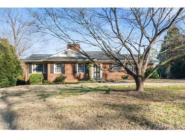 Charming brick home featuring a well-maintained lawn and mature tree in a desirable neighborhood at 3074 Granville Dr, Raleigh, NC 27609