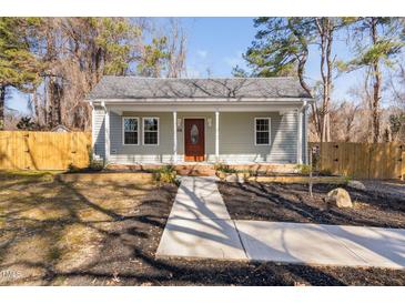 Charming home with a covered porch, tidy landscaping and a quaint walkway leading to the front door at 318 Holland Glen St, Fuquay Varina, NC 27526