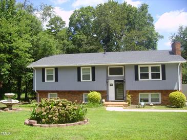 Inviting two-story home with landscaped yard, charming brick accents, and lush green lawn at 4408 Leota Dr, Raleigh, NC 27603