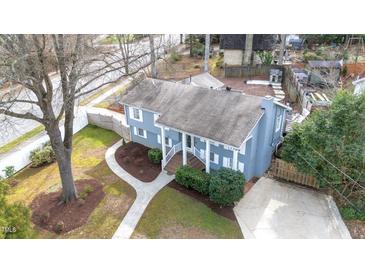 Charming home featuring a well-maintained yard, inviting walkway, and classic architectural details at 5412 Farley Dr, Raleigh, NC 27609