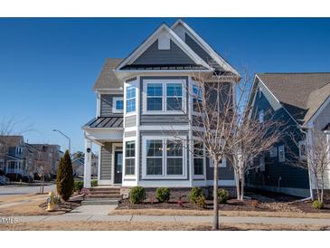 Charming two-story home with gray siding, white trim, and a well-maintained front yard at 5501 Advancing Ave, Raleigh, NC 27616