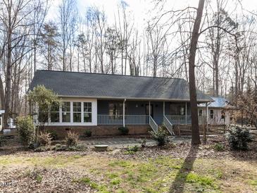 Charming ranch-style home featuring a welcoming front porch and mature trees at 1002 Walker Field Dr, Rougemont, NC 27572