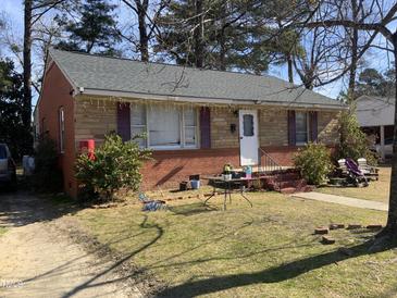 Charming single-story home with a stone and brick facade, complemented by red shutters at 1218 W Pearsall St, Dunn, NC 28334