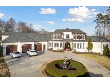 Stately home with circular driveway, water feature, attached three-car garage, and manicured landscaping at 1326 Lochshire Dr, Burlington, NC 27215