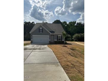 Charming one-story home with gray siding, a two-car garage, and a well-maintained front lawn at 135 Baneberry Dr, Broadway, NC 27505