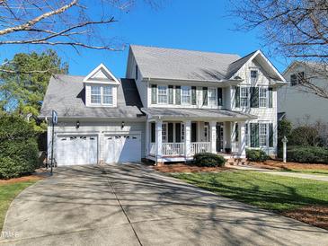 Charming two-story home featuring a welcoming front porch, attached two-car garage, and lush green lawn at 1617 Heritage Club Ave, Wake Forest, NC 27587