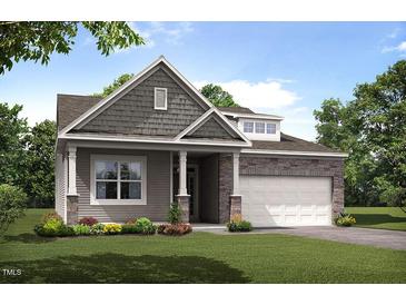 Charming single-Gathering home with stone accents, a covered porch, and a well-manicured lawn at 1633 Wareham Dr, Mebane, NC 27302
