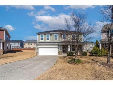 Two-story home features a two-car garage, neutral siding, and a well-manicured front yard at 2000 Muddy Creek Ct, Raleigh, NC 27610