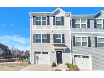 Charming two-story townhome featuring attached garage, classic black shutters, and neat front lawn landscaping at 2005 Silent Bend Dr, Durham, NC 27704