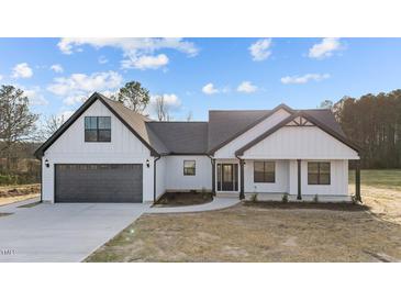 A modern, white farmhouse-style home with a gray roof, dark trim, and an attached two-car garage at 2955 Mt Pleasant Rd, Willow Springs, NC 27592