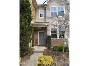 Inviting townhome exterior with charming front door and well-manicured landscaping at 684 Wickham Ridge Rd, Apex, NC 27539