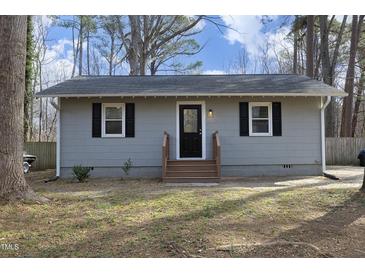 Charming gray home with a newly stained front porch, black door, and black shutters at 8125 Middleton Rd, Garner, NC 27529