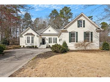 Beautiful brick home featuring manicured lawn, symmetrical windows, shutters and a covered entry way at 8513 Barrett Hall Ln, Wake Forest, NC 27587