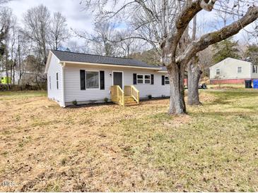 Charming single-story home with light gray siding, black shutters, new front porch, and freshly landscaped yard at 108 Torain St, Hillsborough, NC 27278