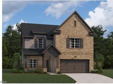 Charming two-story home featuring a brick facade, inviting entrance, and attached two-car garage at 1400 Malcus Ct # 57, Fuquay Varina, NC 27526
