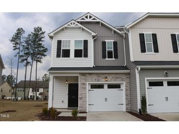 Charming two-story townhome with stone accents and an attached one car garage at 141 Rolesville Ridge Drive Dr, Rolesville, NC 27571