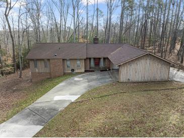 Charming single-story home featuring a long driveway and lush surroundings at 145 Traceway N, Sanford, NC 27332